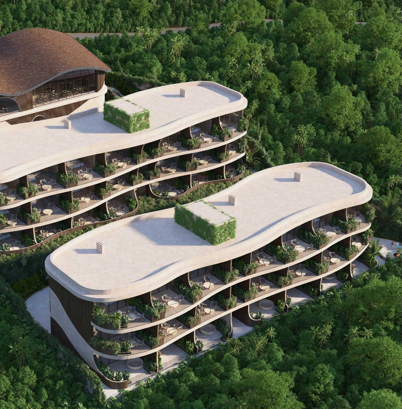 Aerial view of Luma — two residence blocks and the wellness center set into dense jungle in Uluwatu